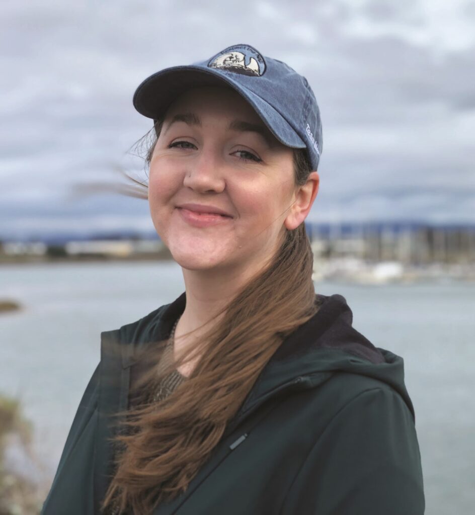 Woman in cap standing in front of the ocean