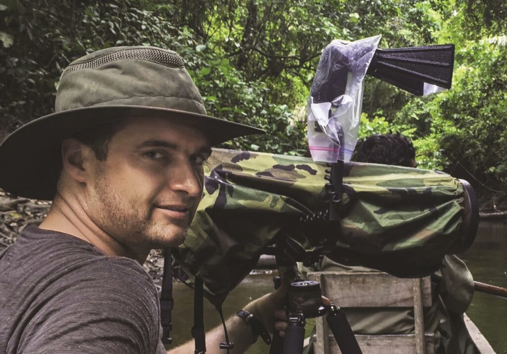 Man in jungle with large camera