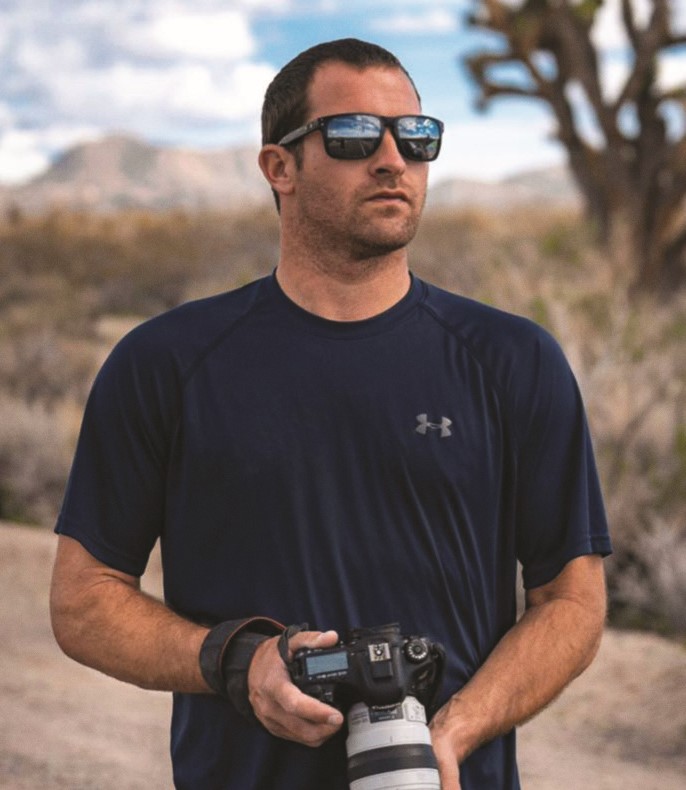 Man in sunglasses with large camera